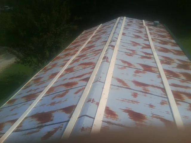 Rusted metal roof panels with new wood purlins before replacement — Storm Damage Roof Repair in Harlowton by Roofing Brothers