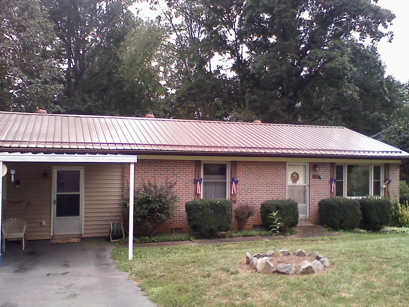 Bronze metal roof and carport on a brick ranch home — Roof Repair work by our crew in Harlowton